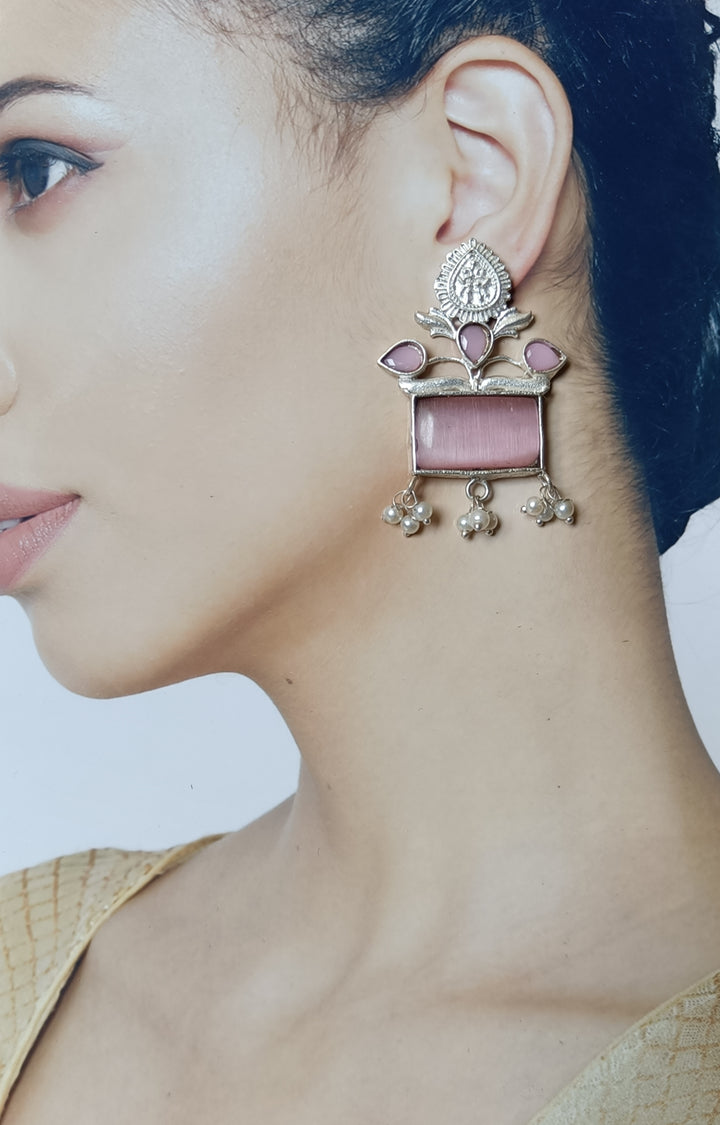 Lustrous pearl centres sit at the heart of this earring.