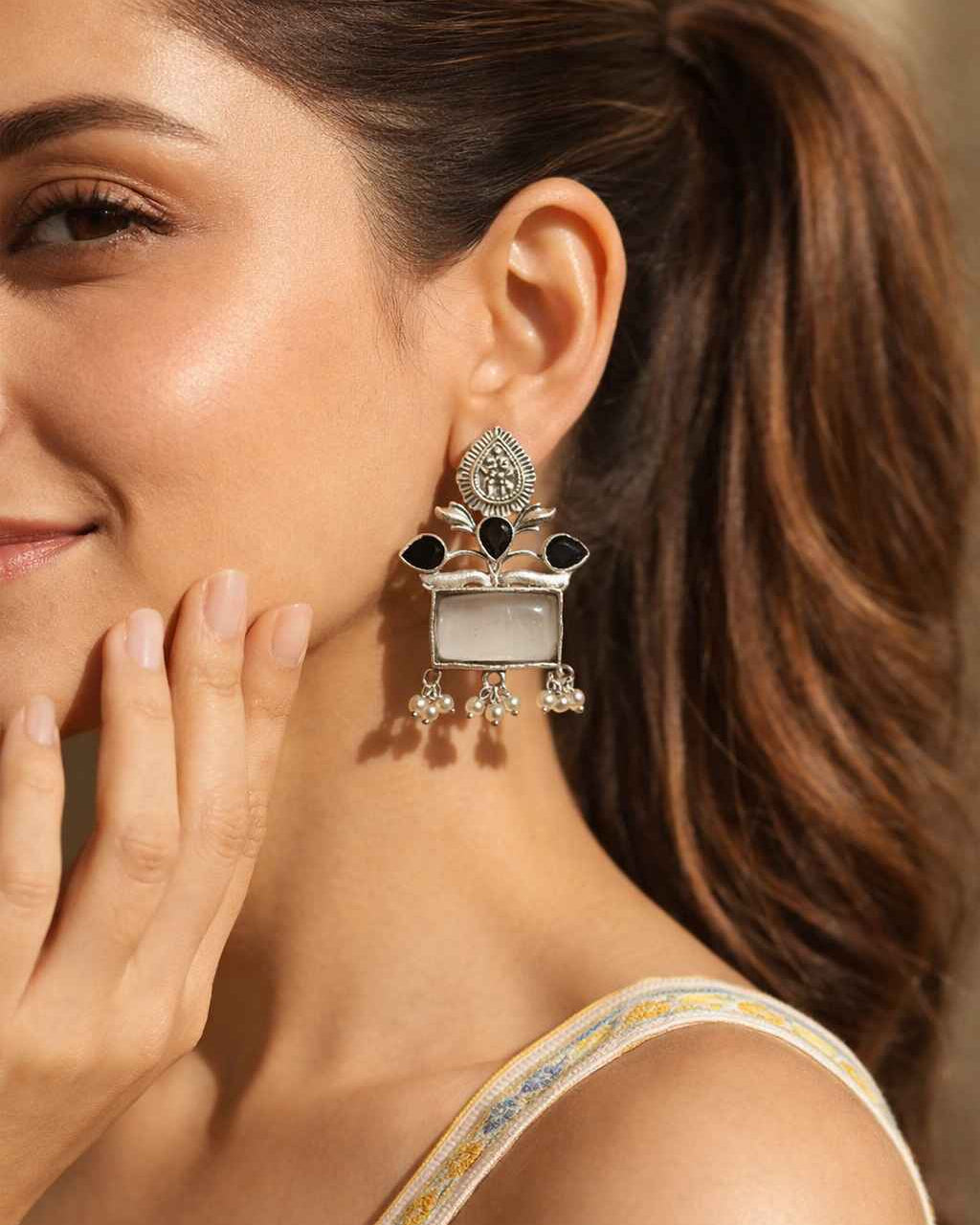 Rounded pearl drops complete the silhouette of this dangler earring.