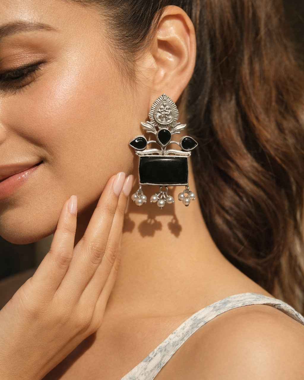 Delicate pearl drops hang from this oxidised silver earring design.