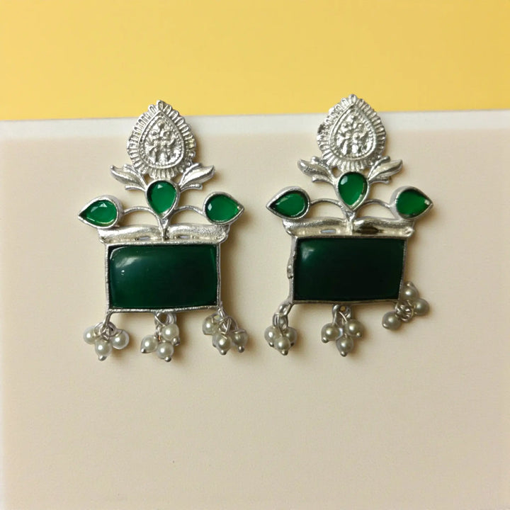 Silver oxidised finish covers the textured surface of this earring.