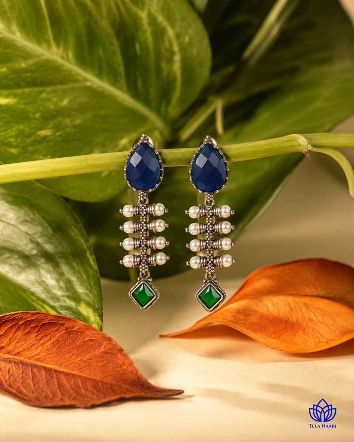 Smooth silver-plated surface highlights the blue teardrop silhouette.