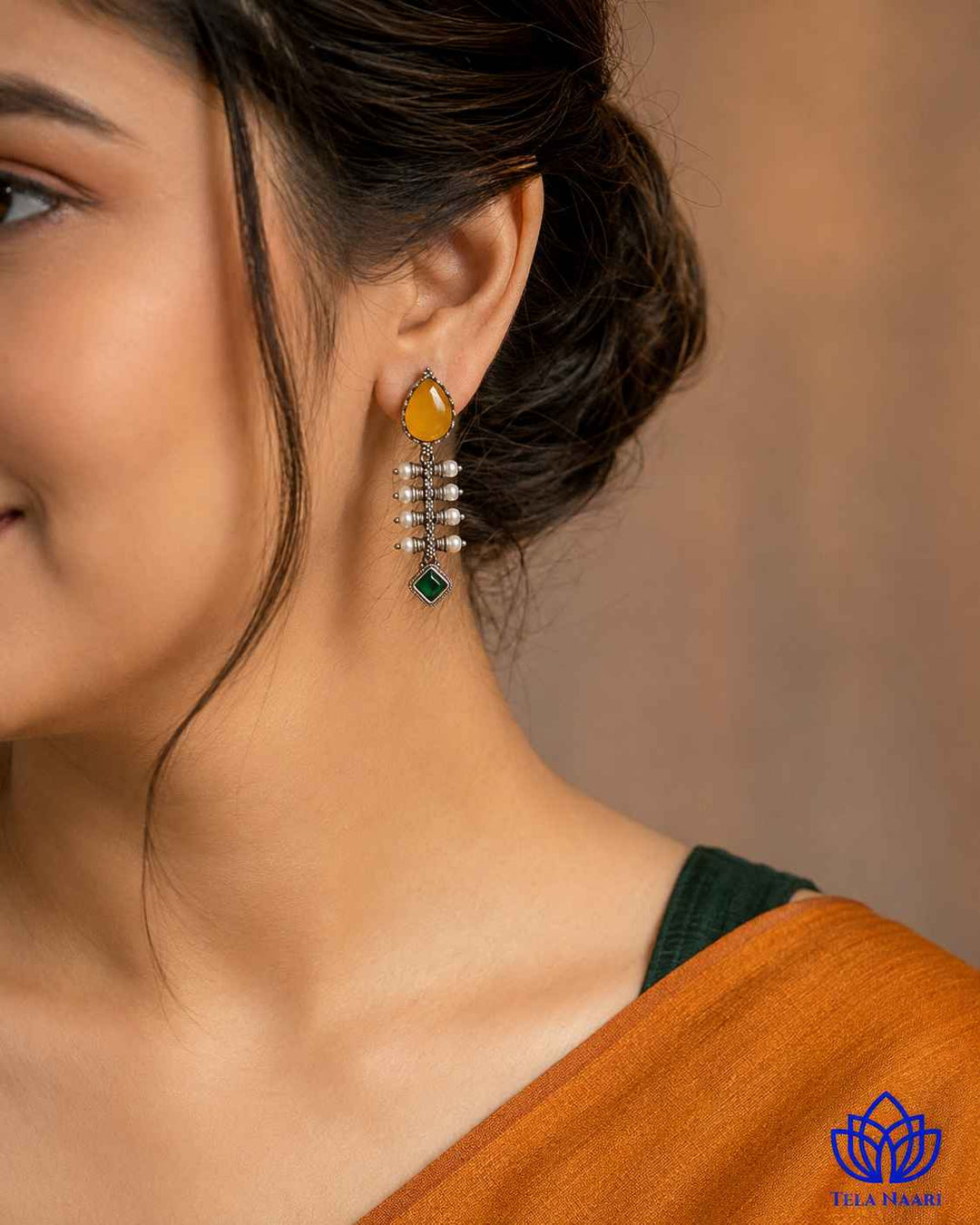 Delicate teardrop design pairs yellow tones with a silver-plated finish.