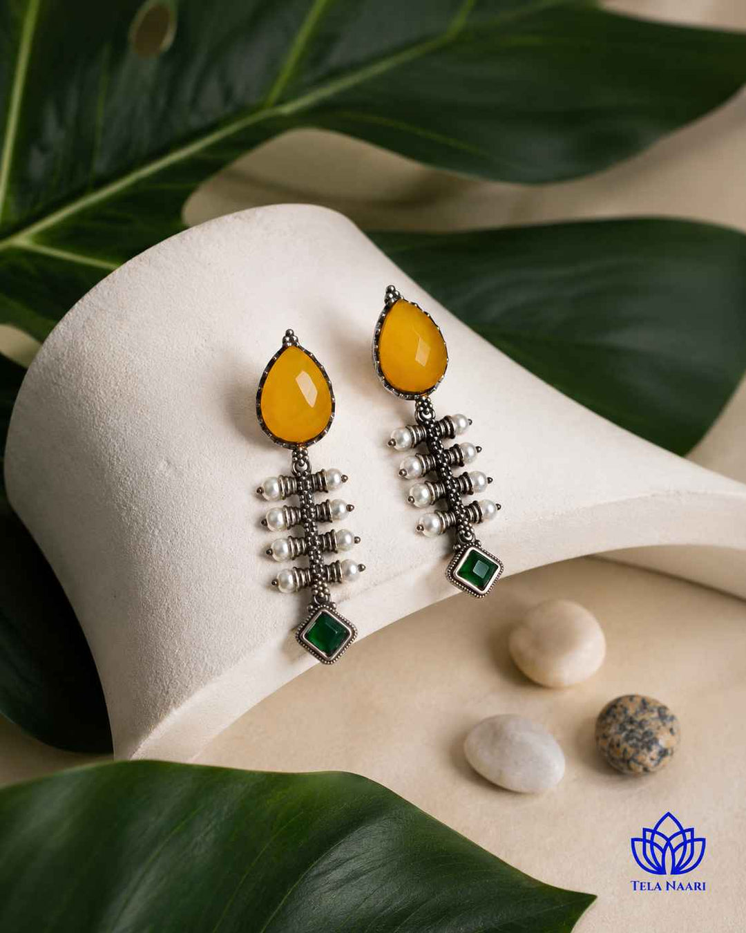 Soft curves define the teardrop silhouette of this yellow earring.