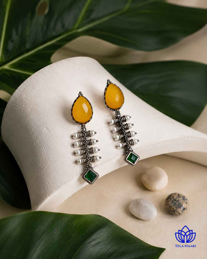 Soft curves define the teardrop silhouette of this yellow earring.