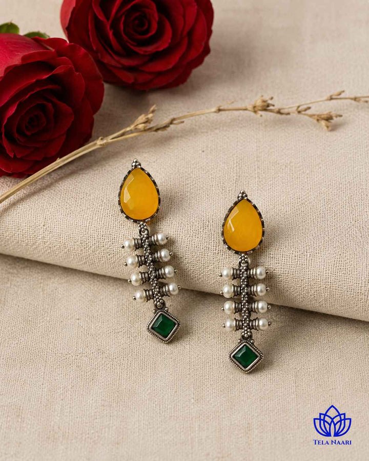 Teardrop-shaped earring features a silver-plated finish in yellow tones.