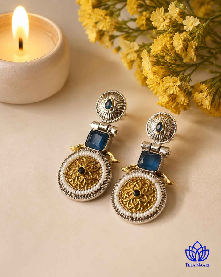 Layered oxidised plating gives this blue earring its dual-tone texture.