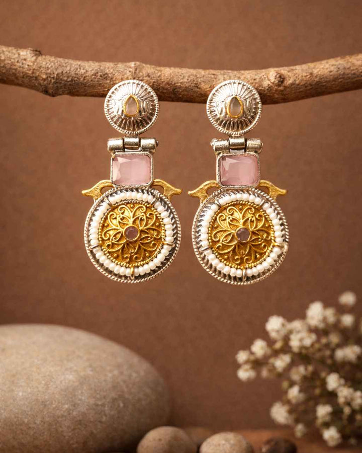 Chic pink tones brighten the dual-tone surface of this earring.