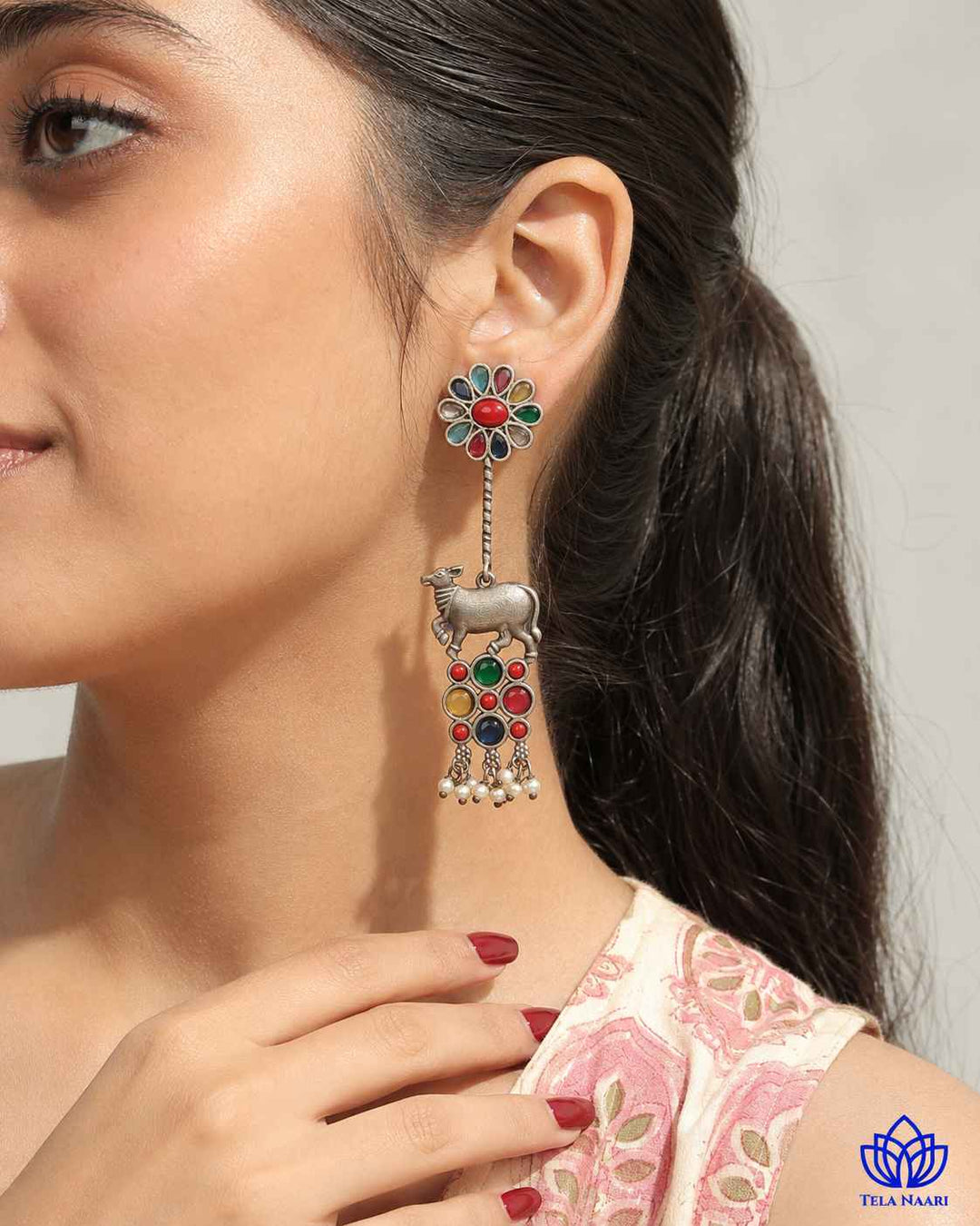 Intricate oxidised craftsmanship defines the folk-art silhouette of this earring.