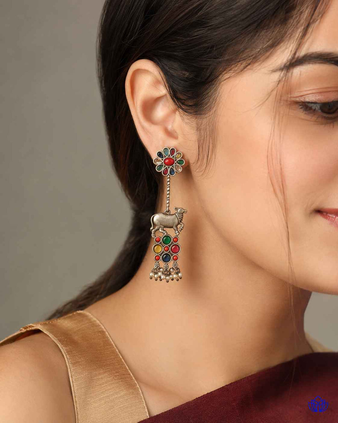 Silver oxidised finish covers the surface of this Nandi earring.