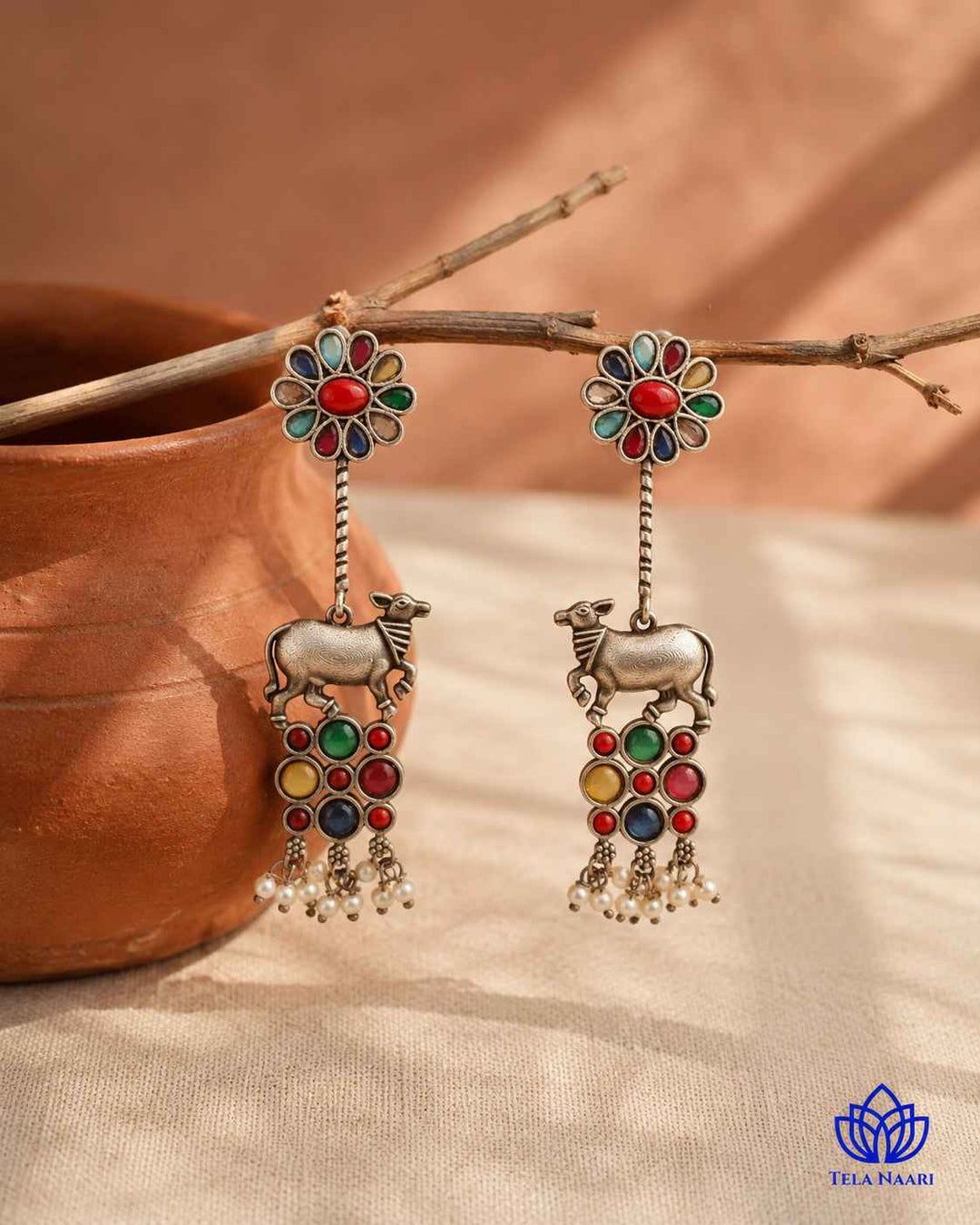 Textured brass surface supports the silver oxidised earring finish.