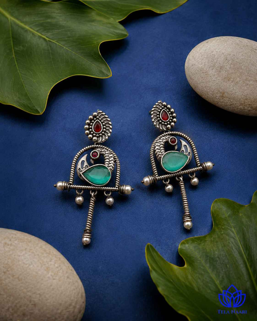 Glass bead detailing decorates the surface of this green earring.