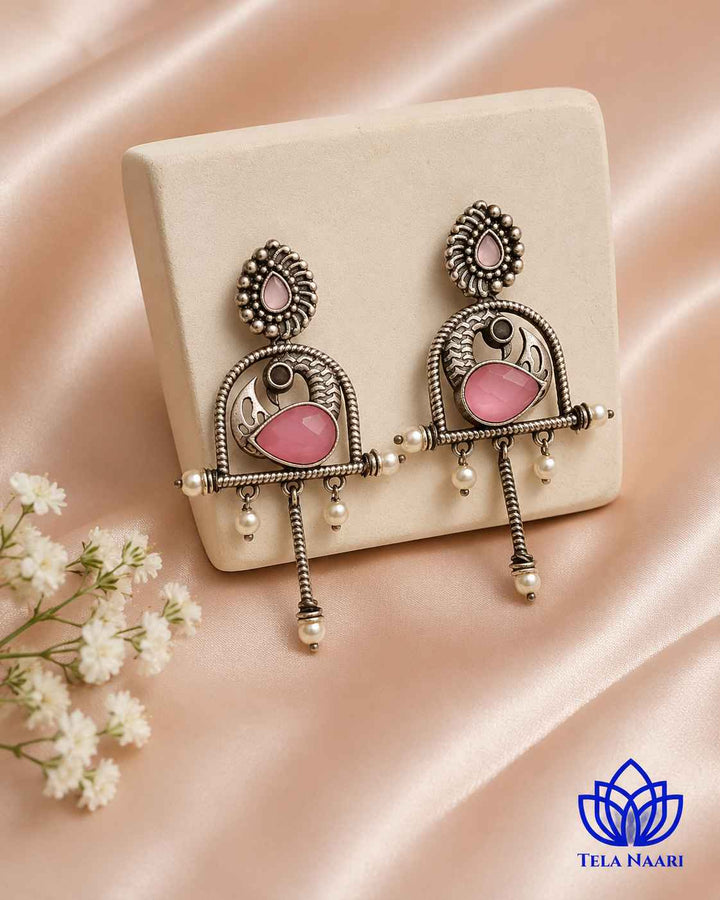 Glass bead detailing decorates the surface of this pink earring.