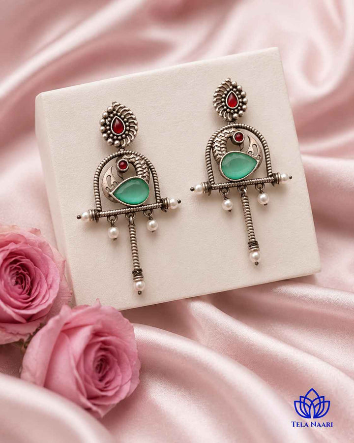 Expressive silhouette gives this oxidised green earring its playful design.