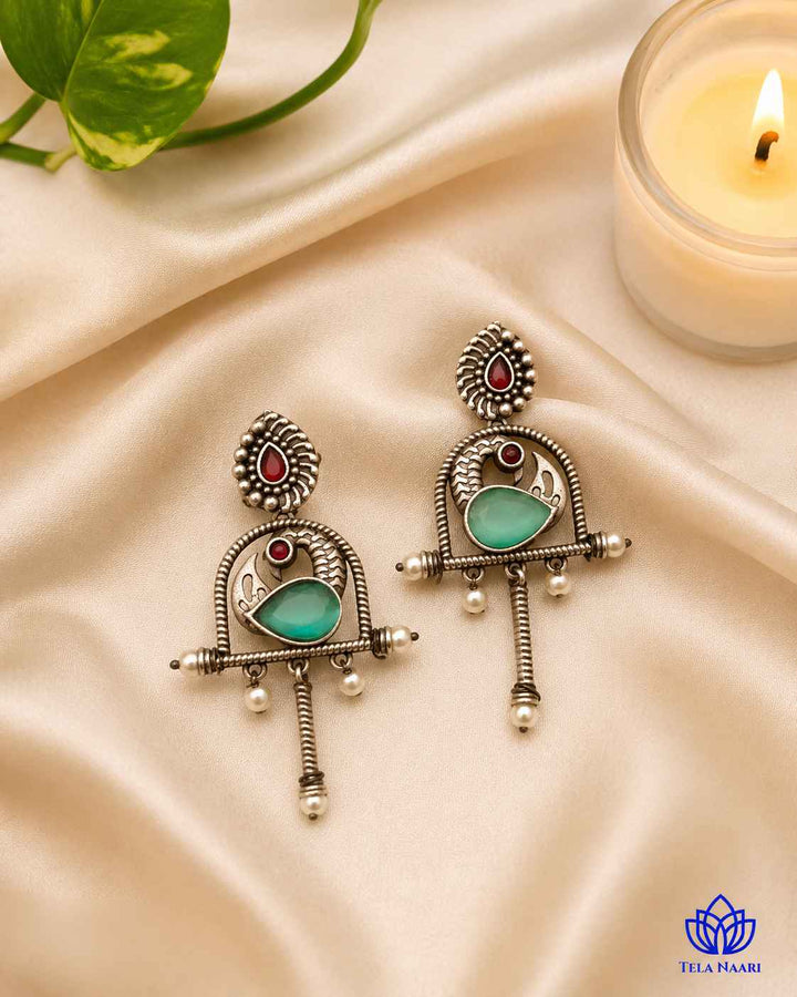 Post and back closure secures this oxidised green earring in place.