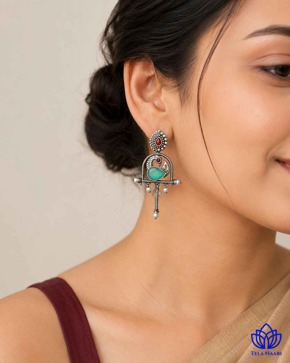 Silver oxidised finish covers the surface of this green earring.