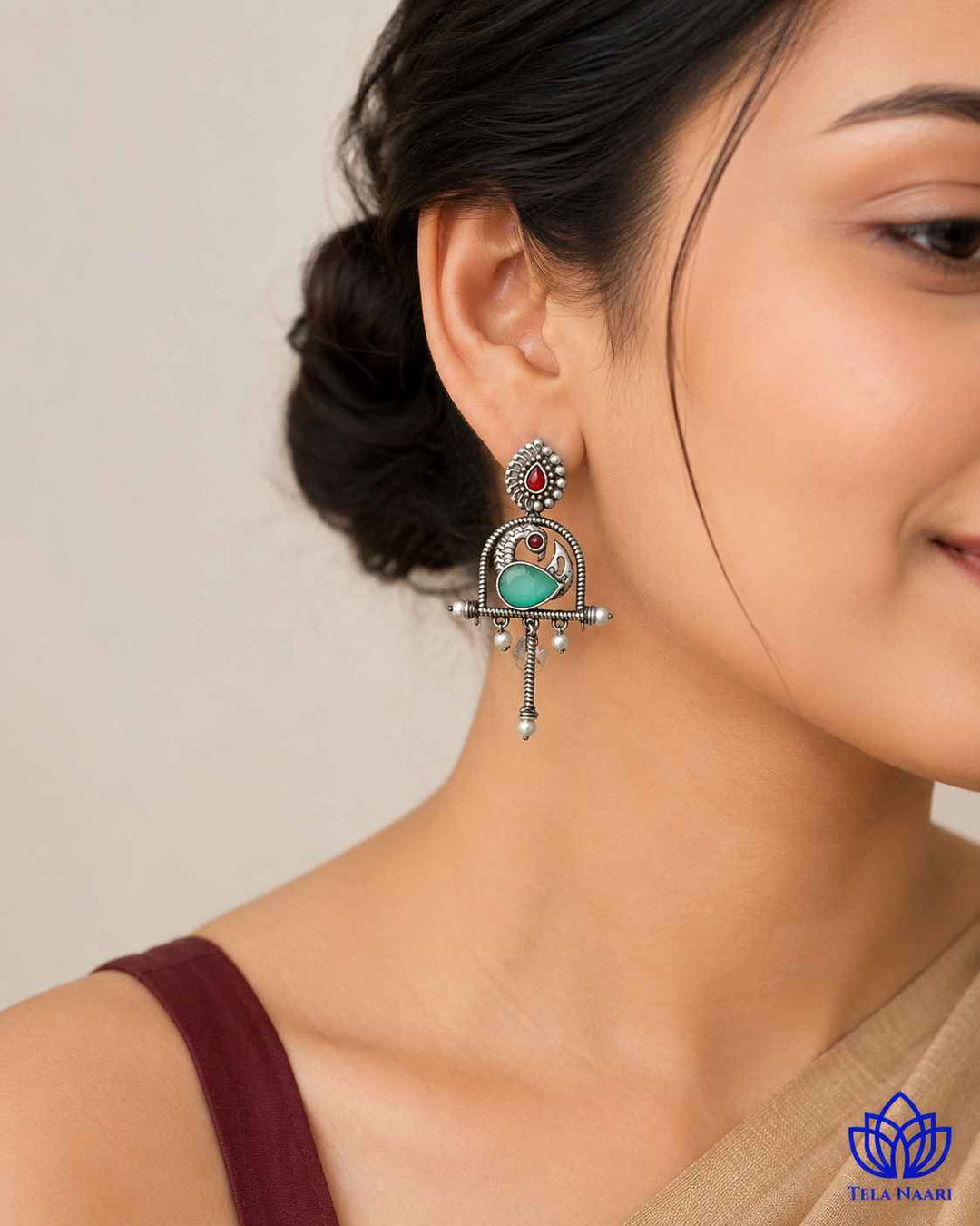 Silver oxidised finish covers the surface of this green earring.