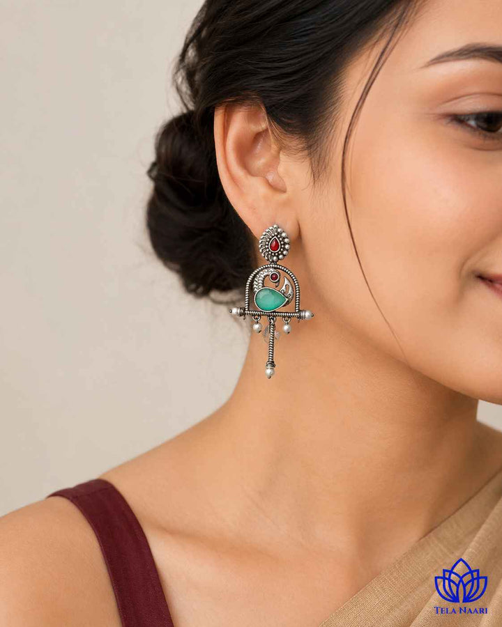 Silver oxidised finish covers the surface of this green earring.