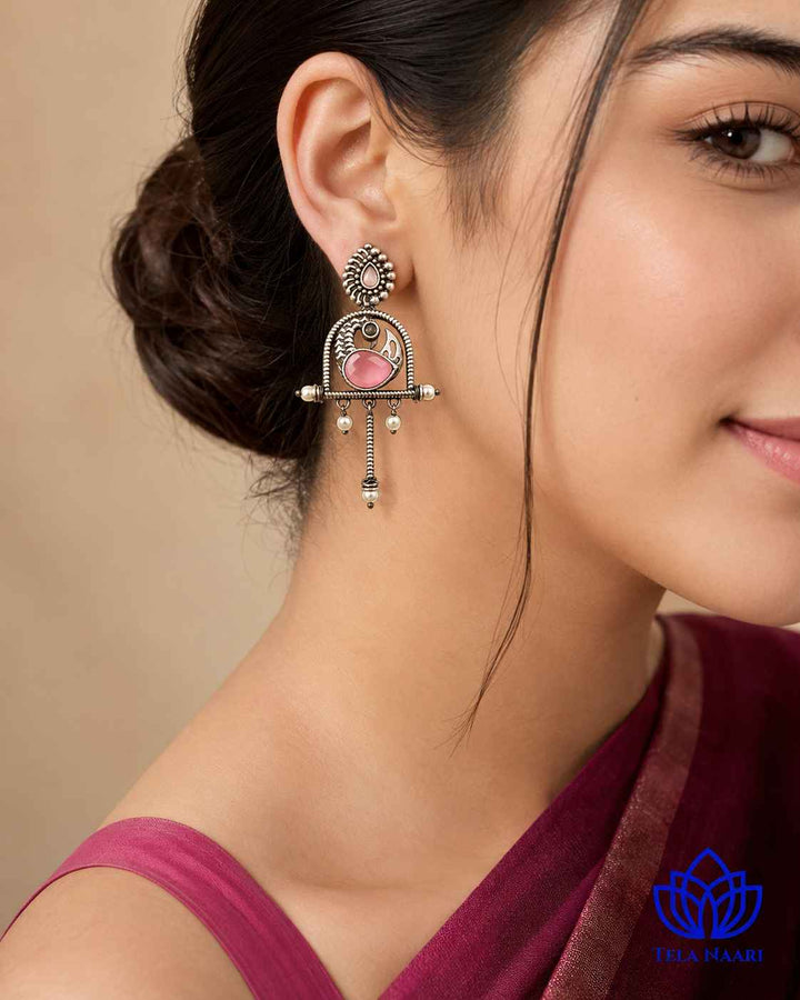 Statement silhouette pairs brass with an oxidised pink finish.