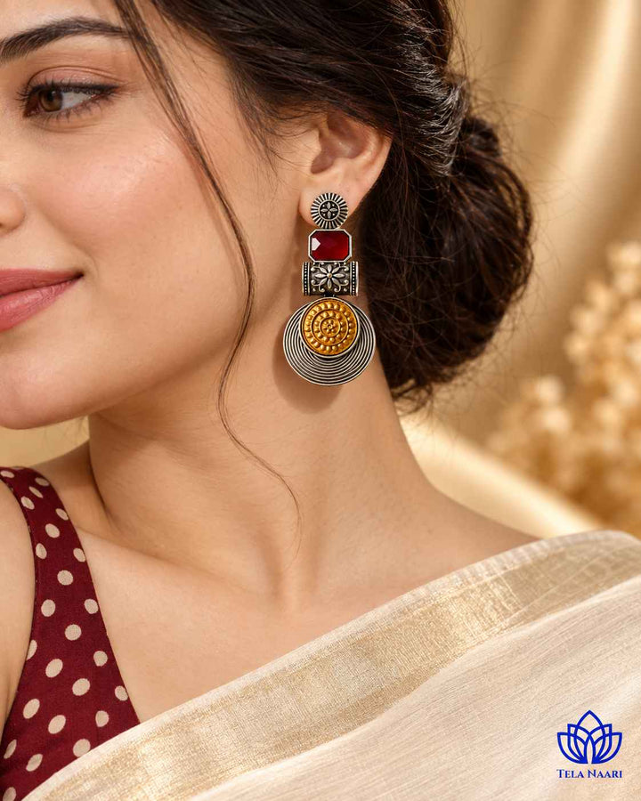 Bold red tones brighten the dual-tone surface of this earring.