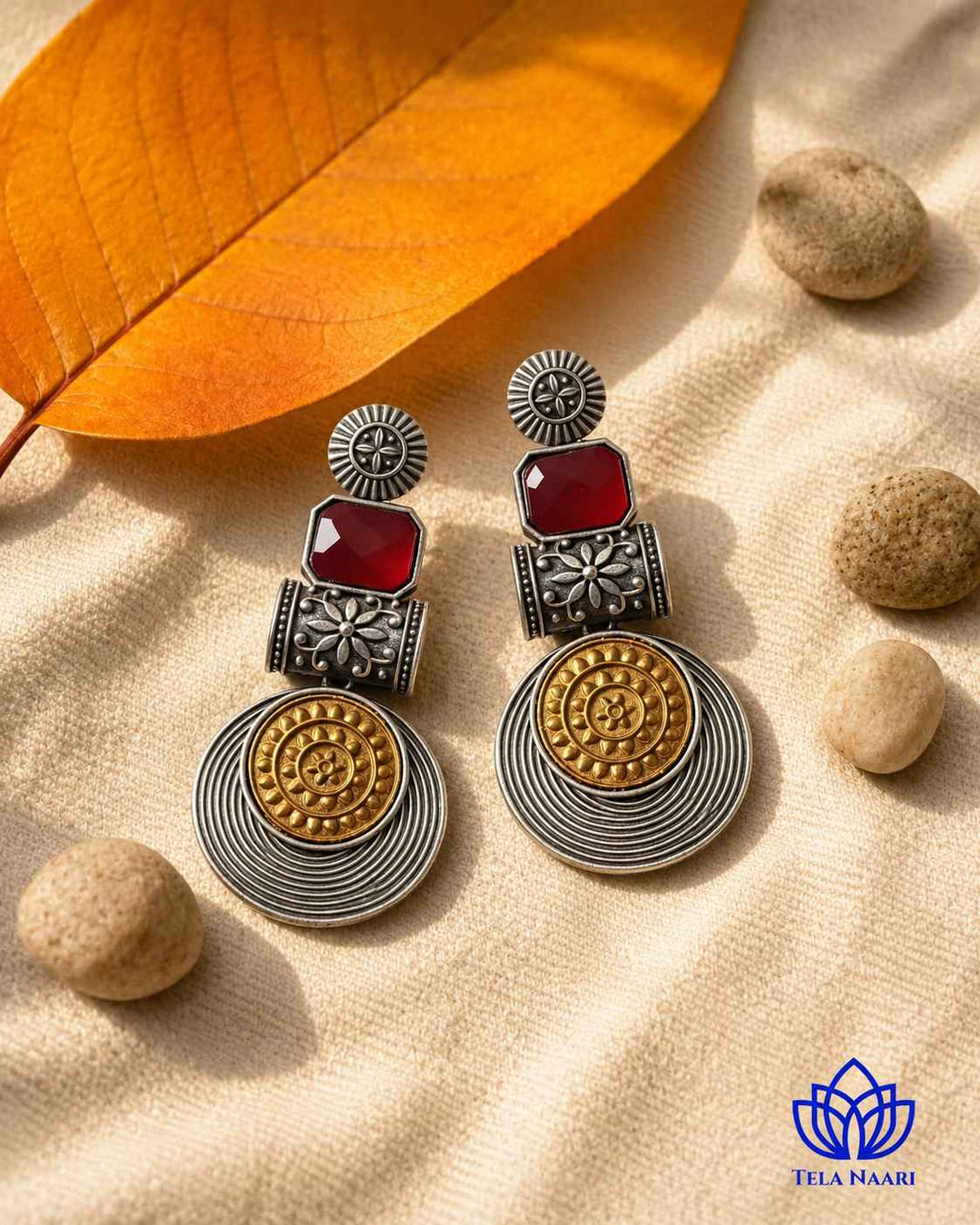 Bold red tones brighten the dual-tone surface of this earring.
