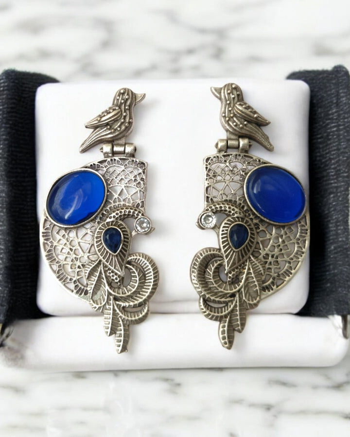Polished brass forms the sturdy base of this earring.
