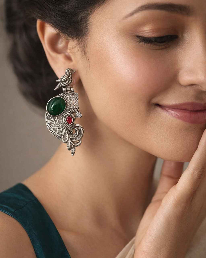 Captivating silhouette pairs a bird motif with stone accents.