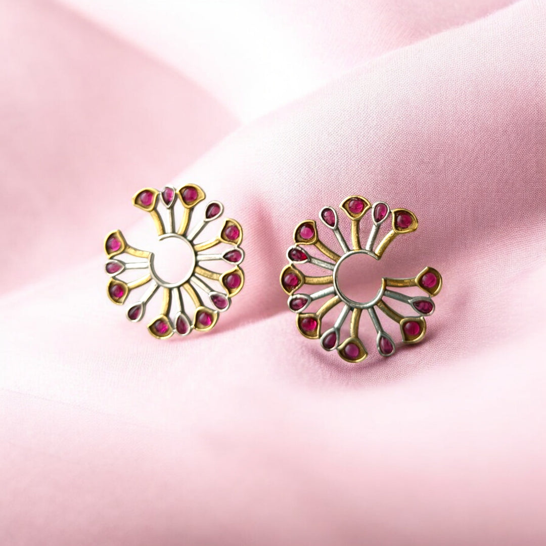 Brass construction supports the fan-shaped peacock design of this earring.