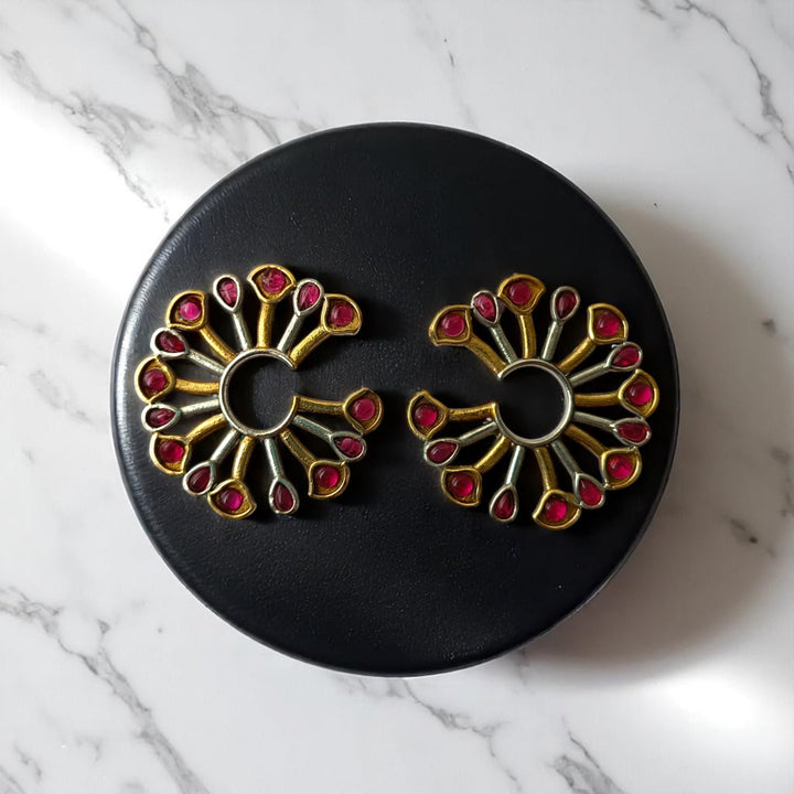 Statement silhouette pairs brass with dual-tone peacock plating.