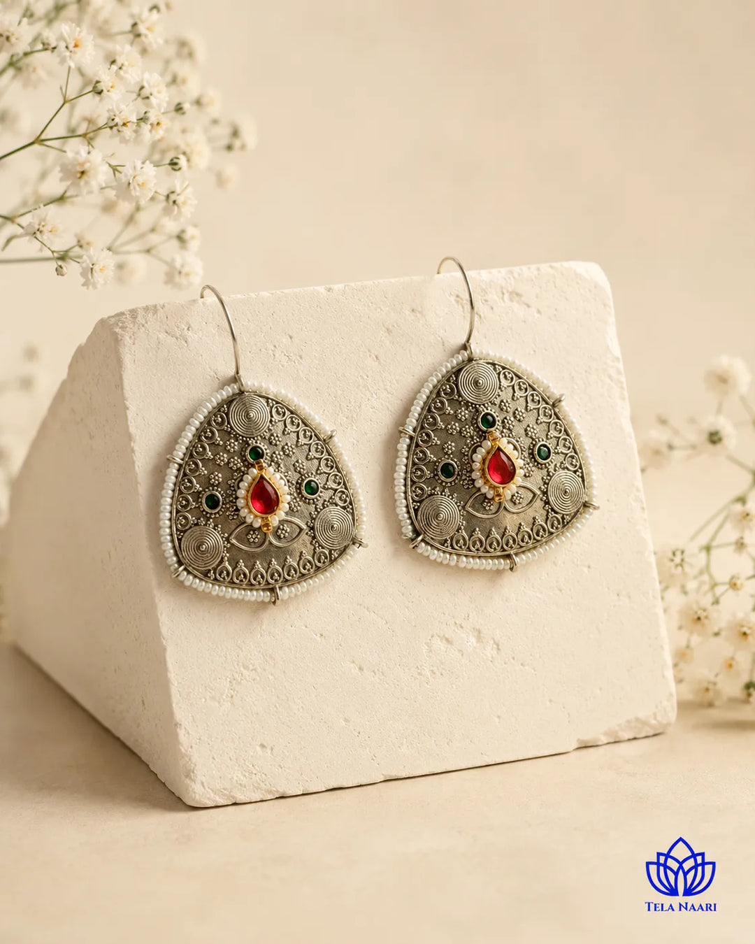 Delicate detailing highlights the pearl accents of this hoop earring.