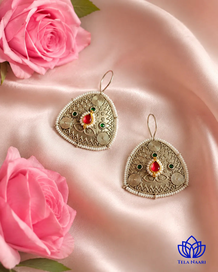 Artisanal geometric detailing shapes this Afghani-inspired hoop earring.