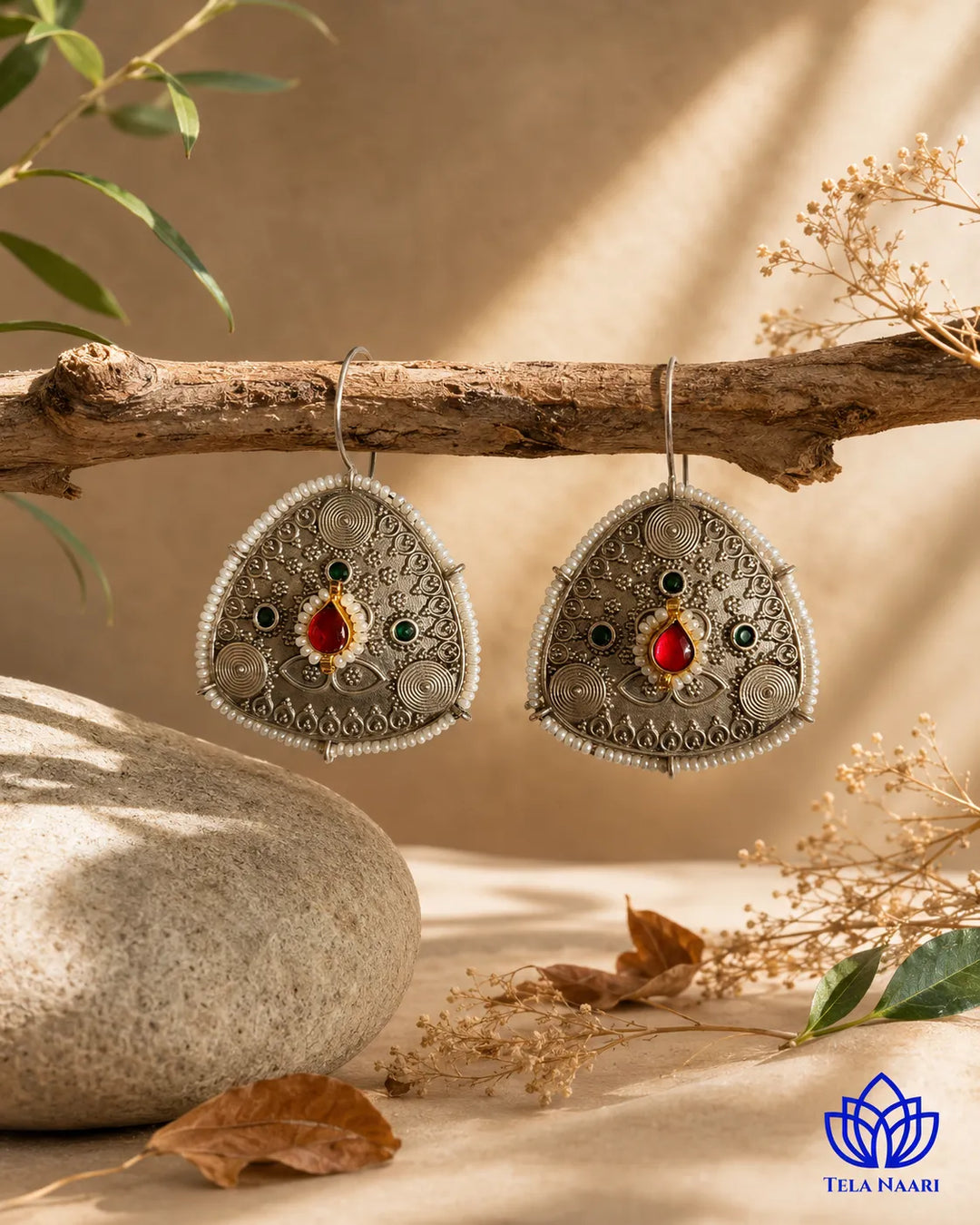 Statement silhouette pairs ruby accents with oxidised silver plating.