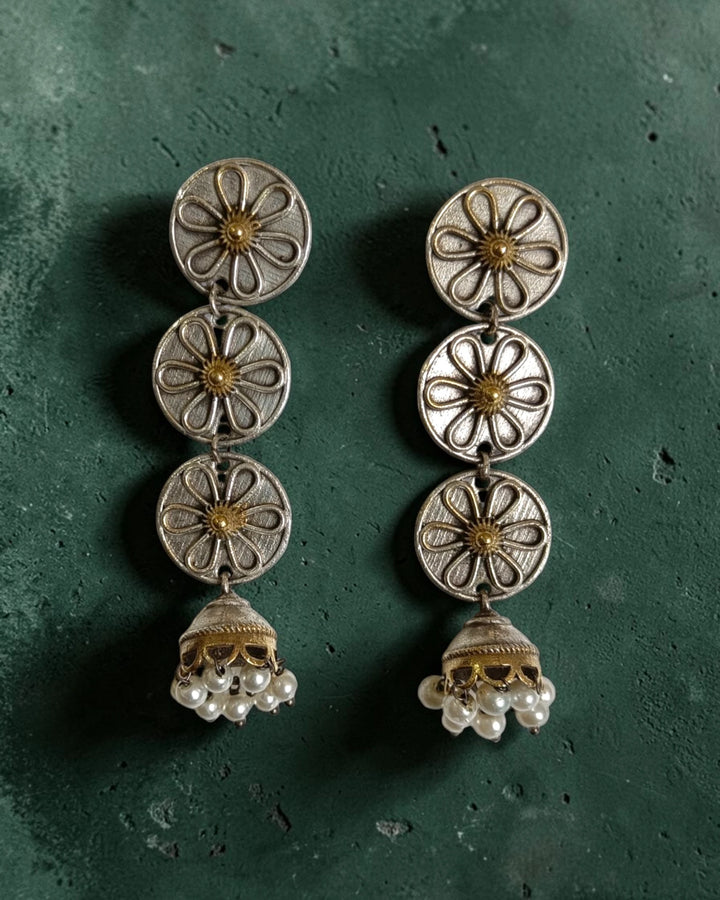 Silver-plated finish covers the surface of this jhumka earring.