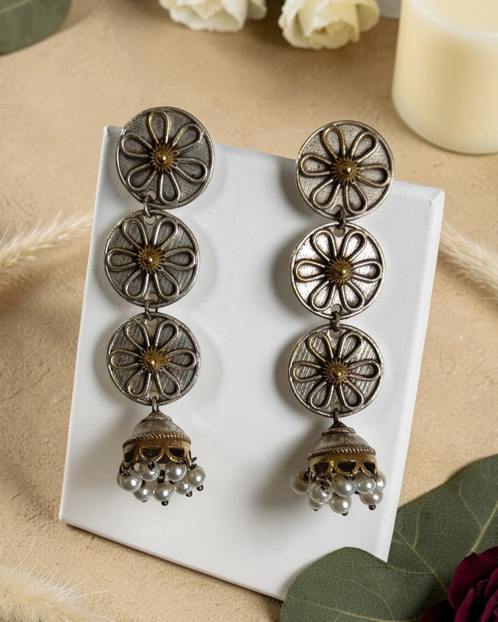 Cascading triple-disc design shapes the silhouette of this jhumka.