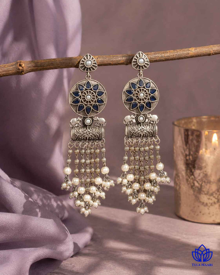 Smooth silver-plated surface highlights the blue teardrop silhouette.
