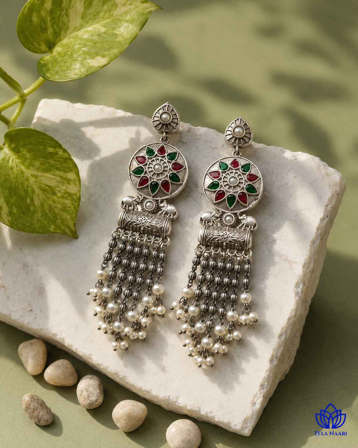 Layered beadwork brings depth to this red and green earring.