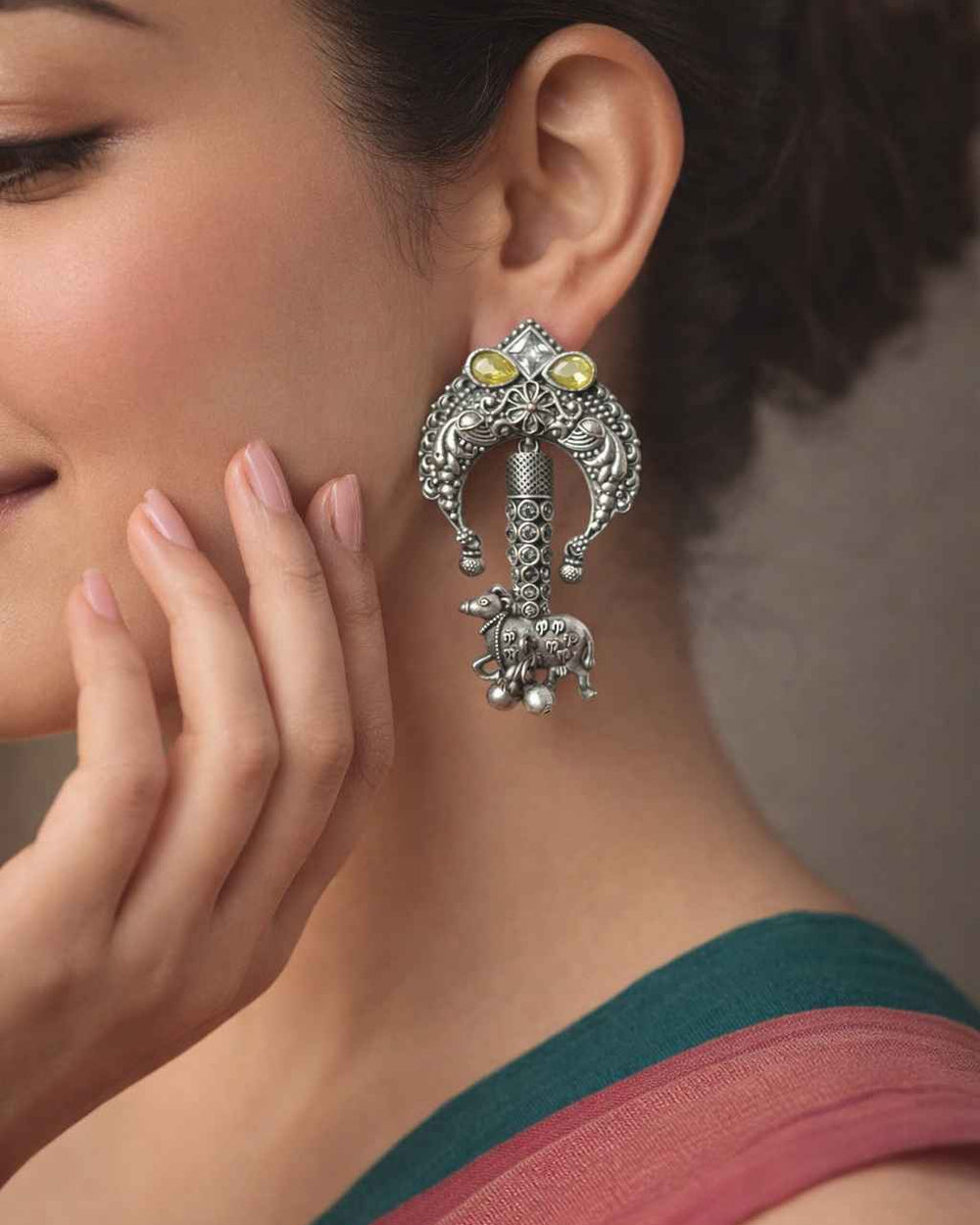 Silver oxidised finish covers the textured surface of this earring.