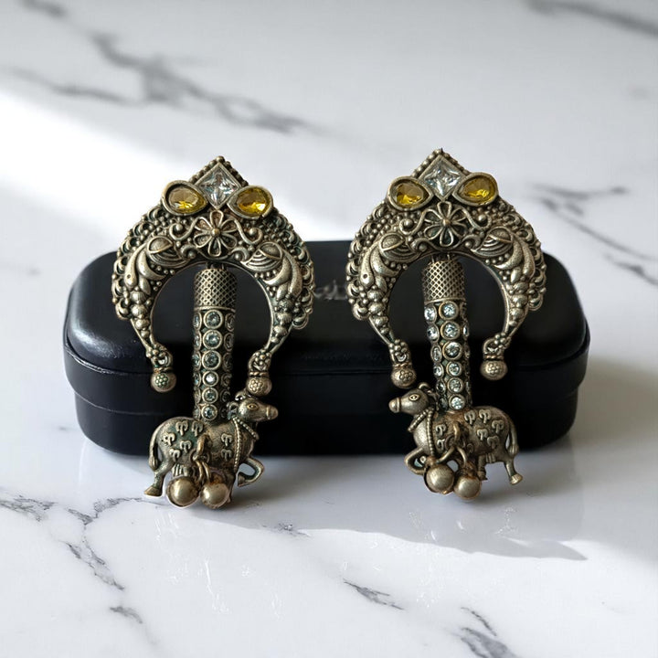 Bold tusk silhouette pairs brass with an oxidised silver finish.