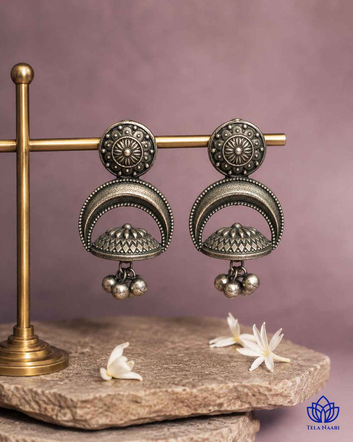 Dome-shaped earring showcases oxidised detailing across its surface.