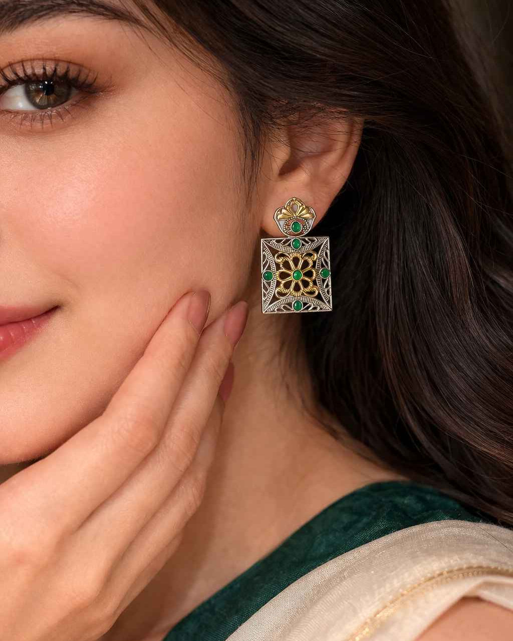Textured brass surface supports the dual-tone square earring finish.