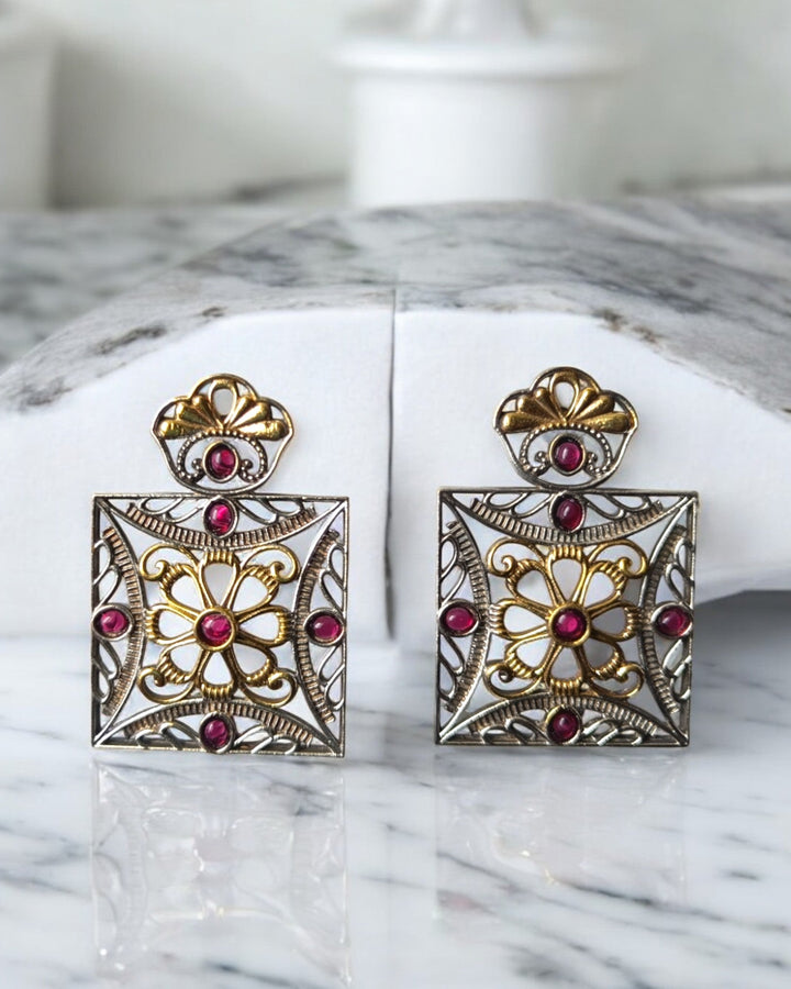 Intricate stone work decorates the surface of this square earring.
