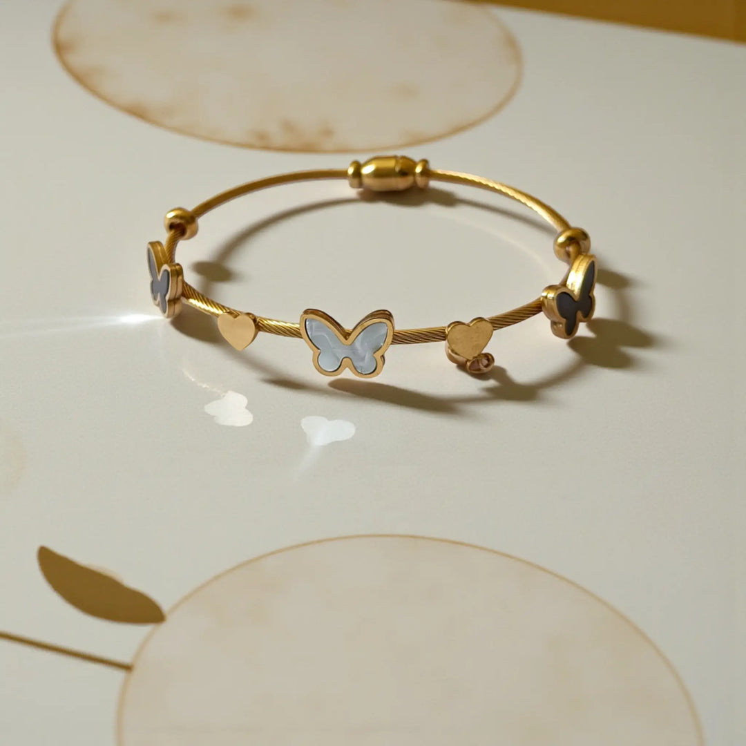 Anti-tarnish butterfly and heart bracelet for women featuring delicate charms and glossy gold finish
