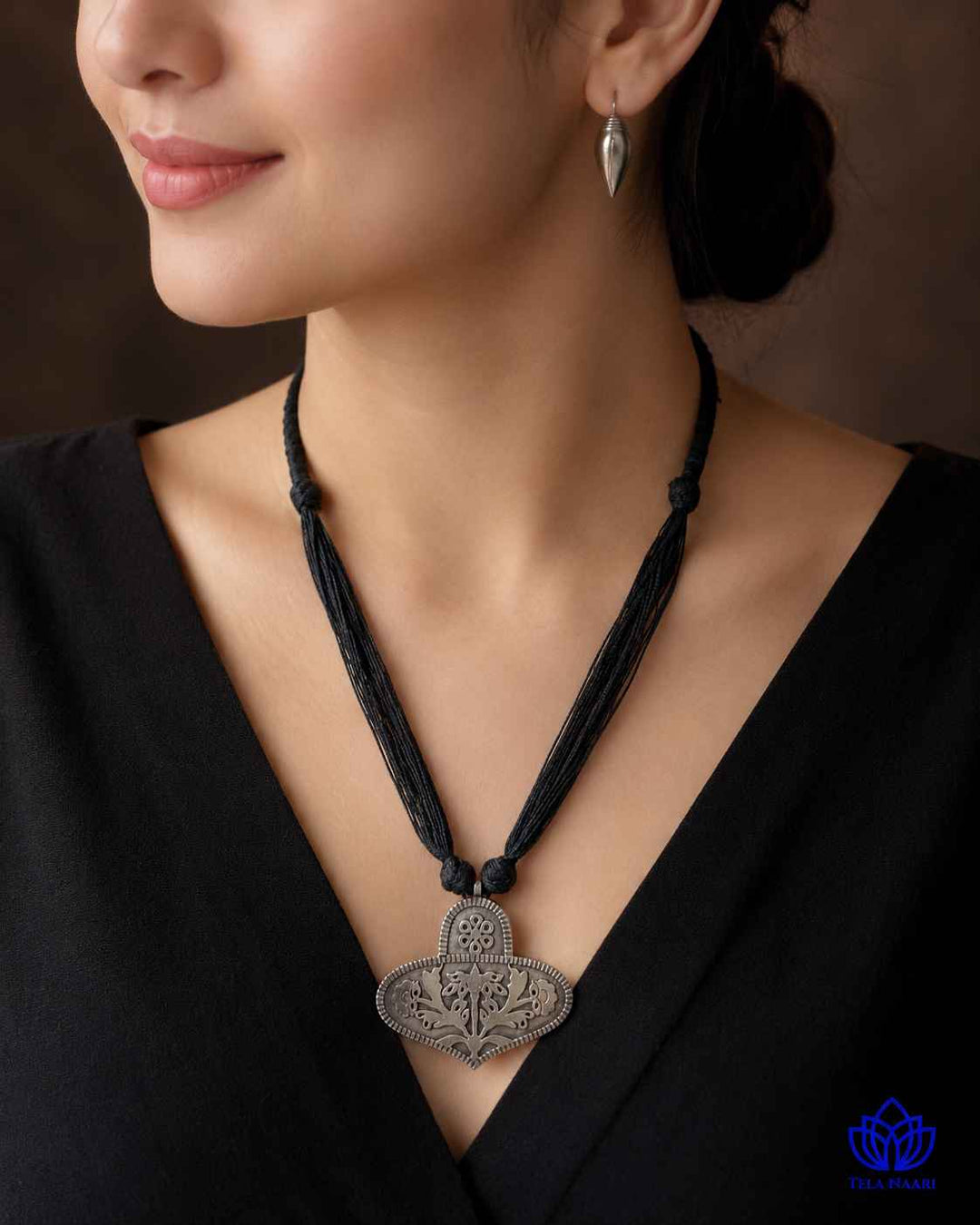Bold black thread detailing shapes this silver-plated necklace set.