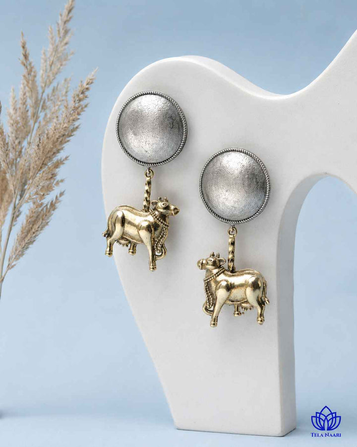 Delicate stone accents highlight the whimsical cow-motif design.