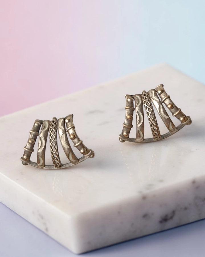 Brass construction supports the curved cage design of this stud.
