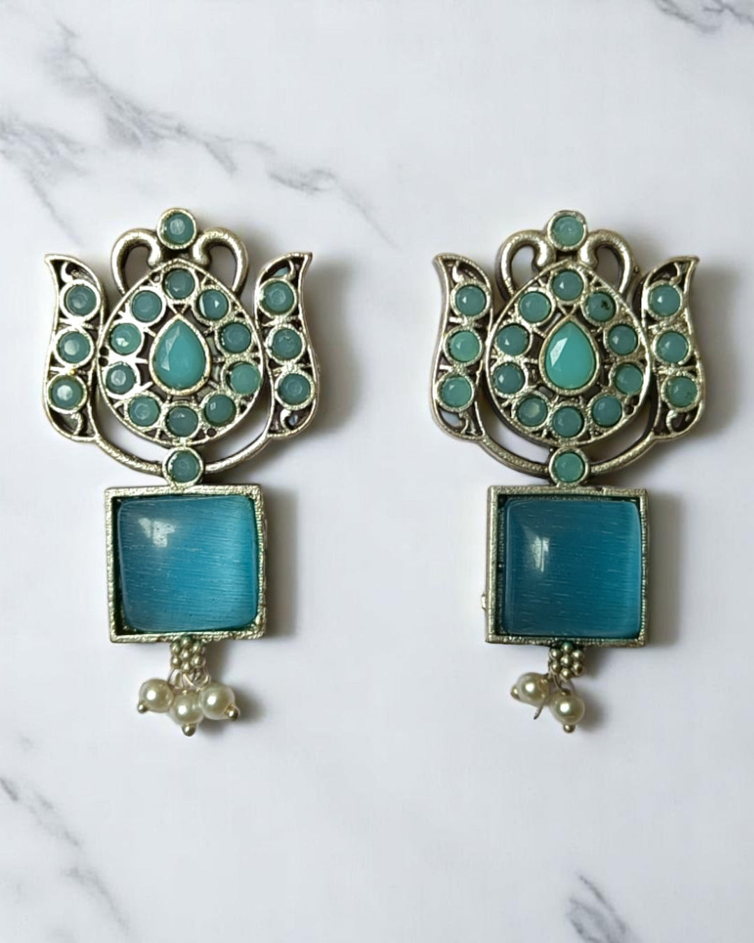 Peach accent brings colour to this silver oxidised earring design.