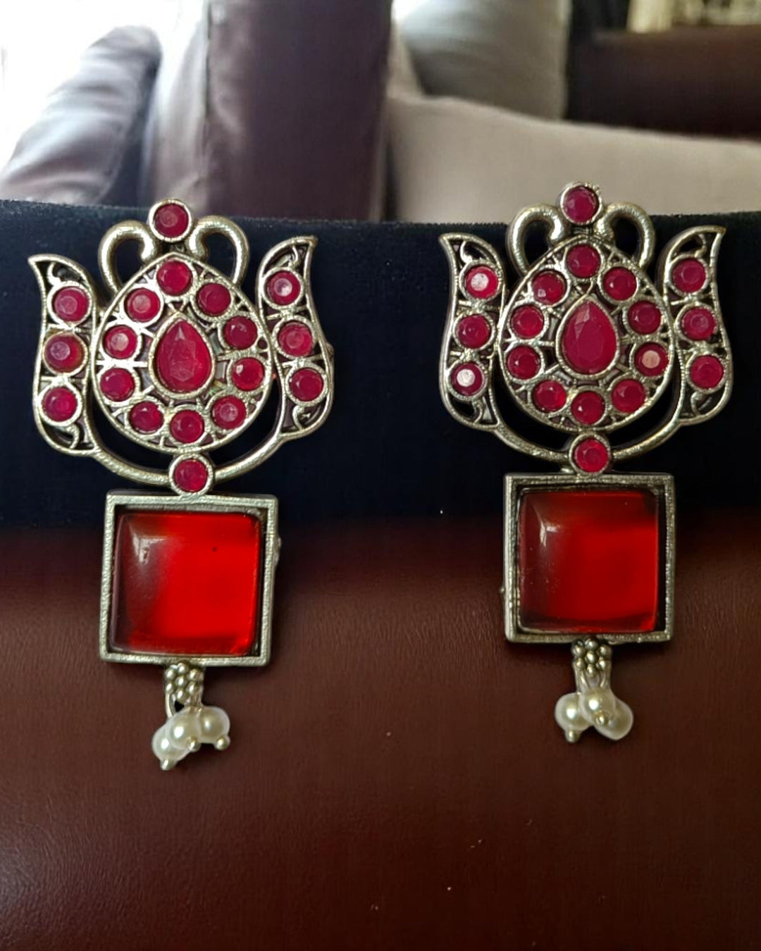 Silver oxidised finish covers the intricate surface of this earring.