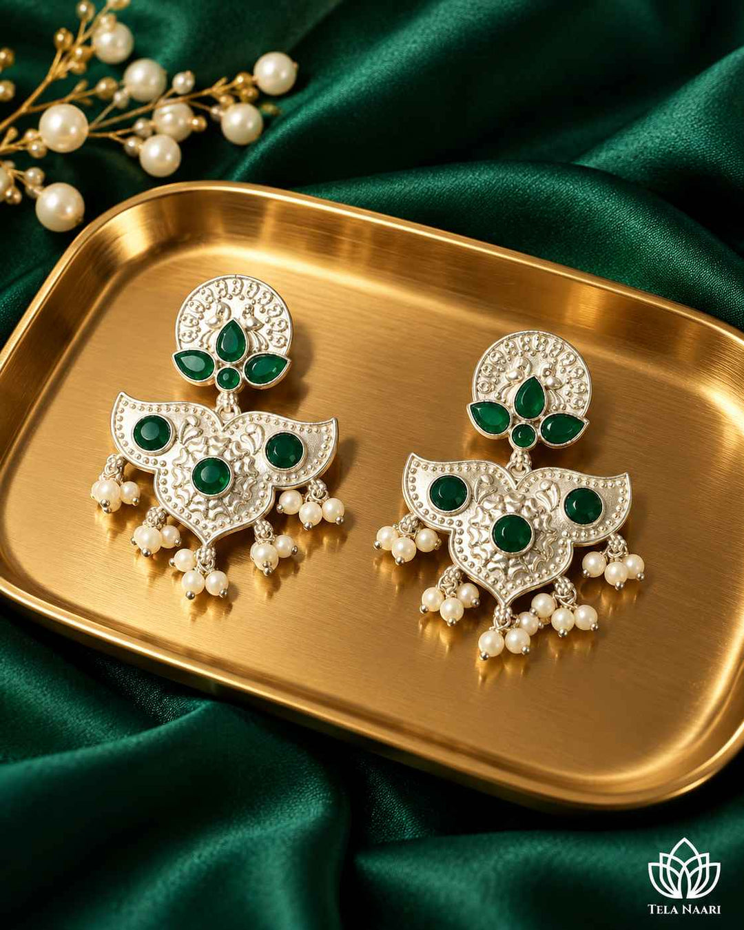 Verdant green accents shape the antique silhouette of this earring.