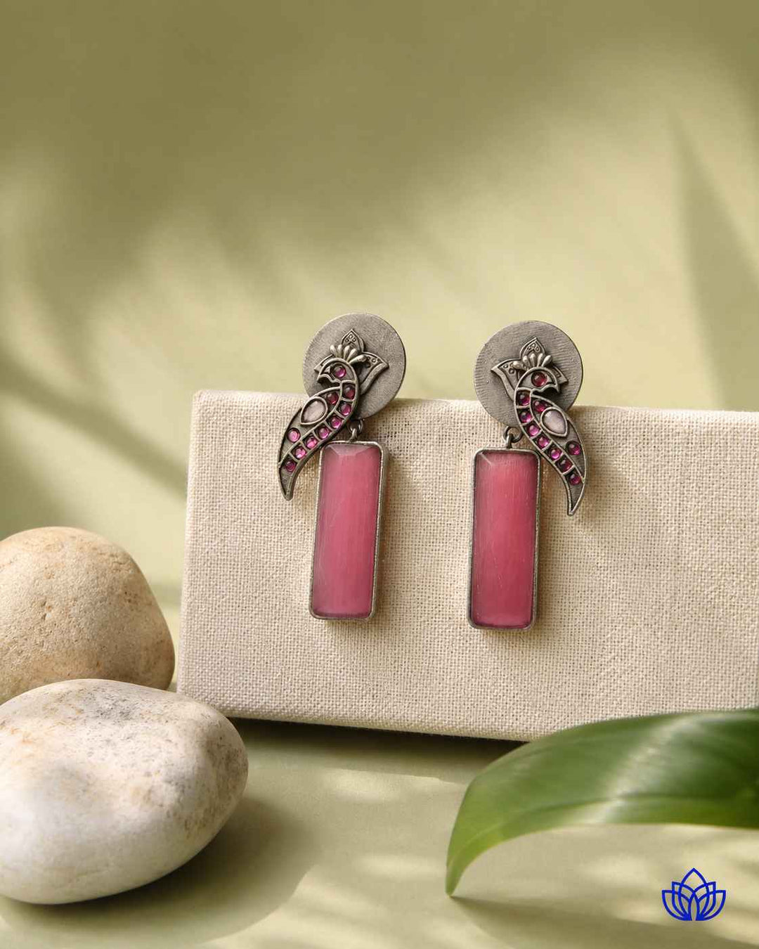 Pink tone brightens the silver-plated surface of this earring.