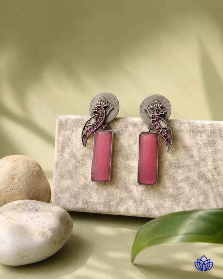 Pink tone brightens the silver-plated surface of this earring.
