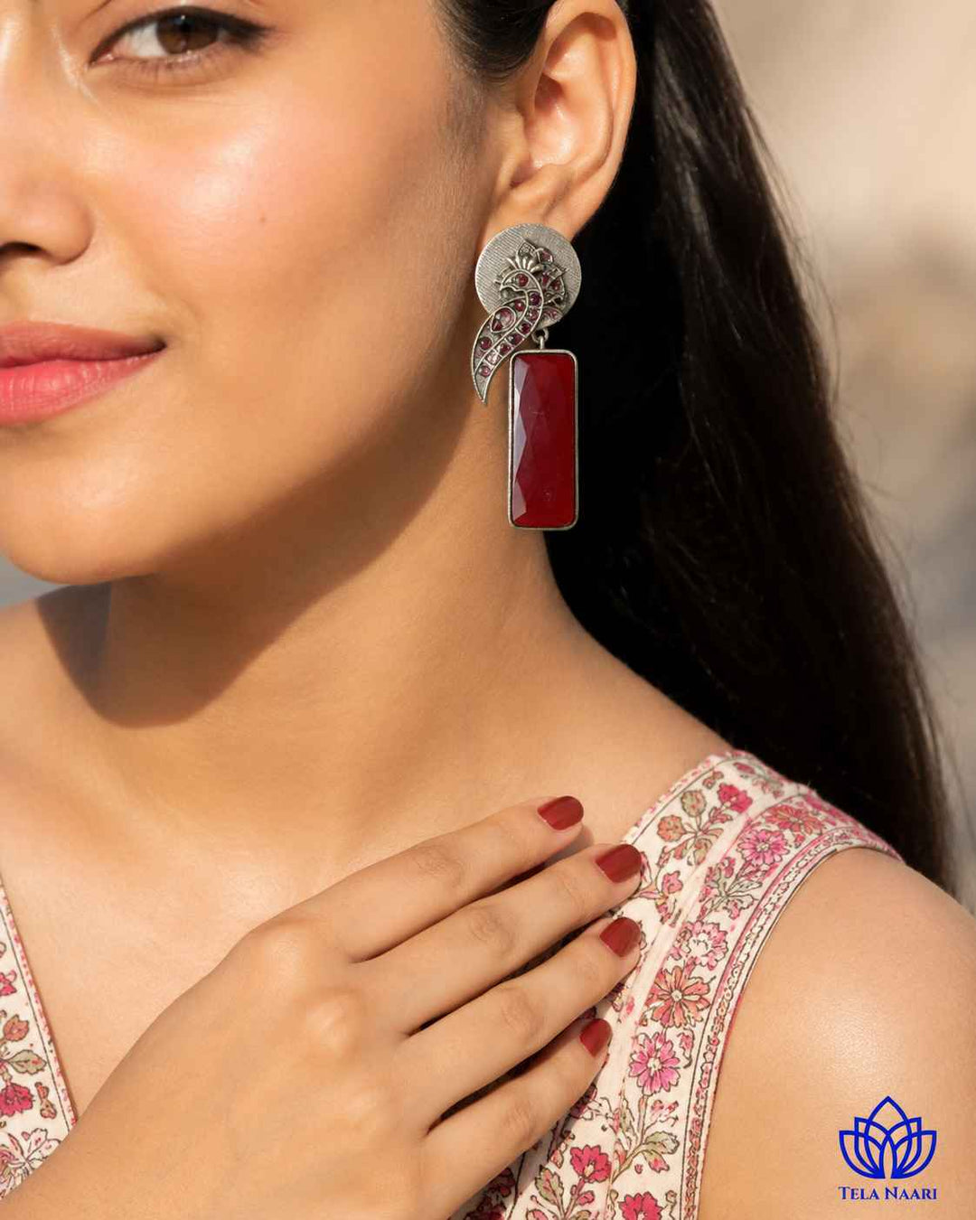 Delicate stone work highlights the intricate design of this earring.